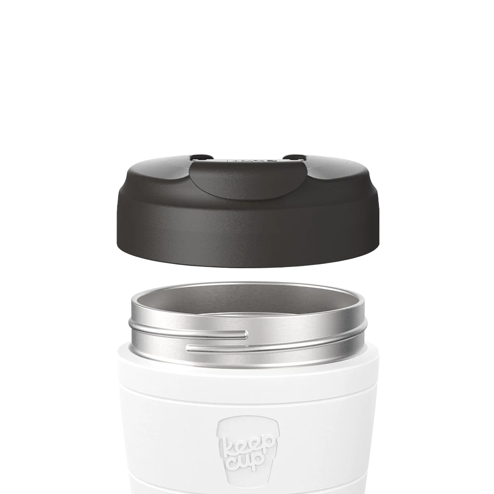 Black Commuter Flip Lid shown lifted above a white KeepCup with stainless steel rim, demonstrating how the lid separates from the cup body in an exploded product view.