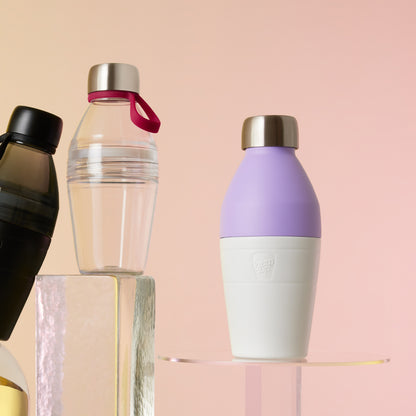 Display of 3 different KeepCup water bottles on a reflective surface with a pink background