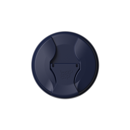 Top-down view of the KeepCup Commuter Flip Lid in Navy, showing the circular lid with curved drinking opening and flip closure tab embossed with the KeepCup logo.