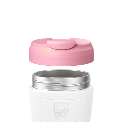 White reusable coffee cup with pink silicone lid and stainless steel band, shown with lid floating above cup