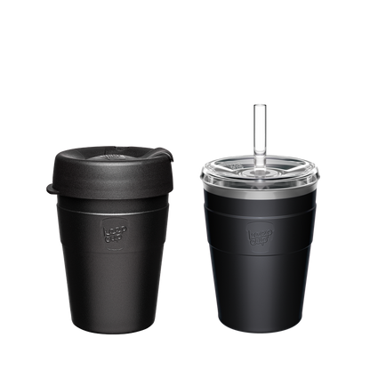 Two black KeepCup reusable coffee cups - one with black lid, one with clear lid and straw, showing eco-friendly travel mug options