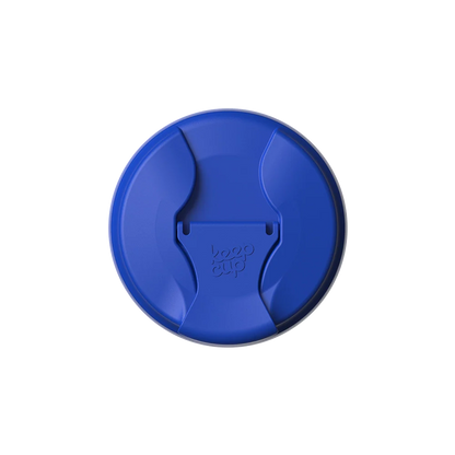 Top-down view of the Commuter Flip Lid in Electric Blue, showing the circular lid with its closed sipper opening and embossed KeepCup logo in the center.