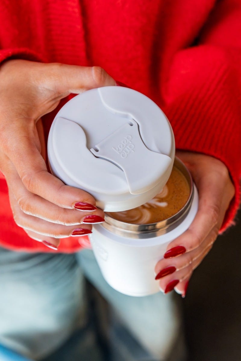 Woman lifting KeepCup Commuter lid off screw fit travel Mug