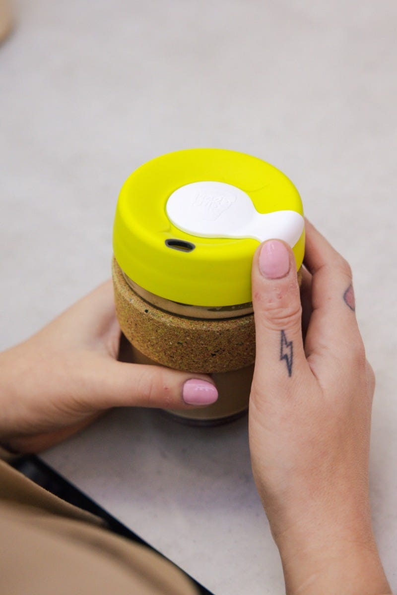 Woman holding KeepCup Brew Cork Ace 12oz with coffee