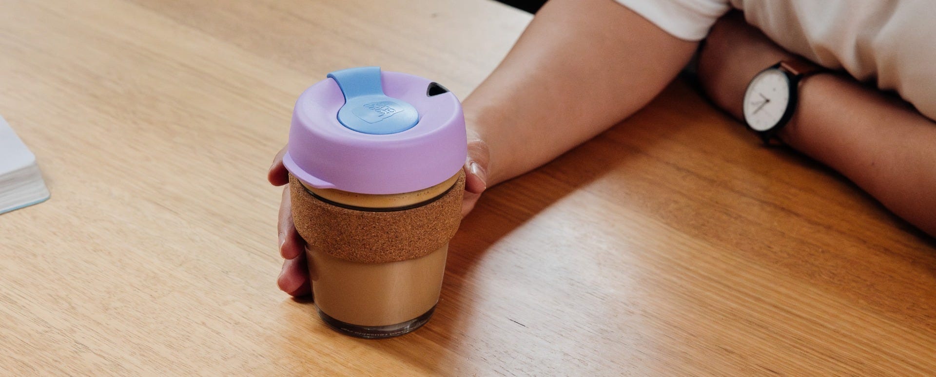 Woman holding KeepCup Brew Cork 12oz with coffee