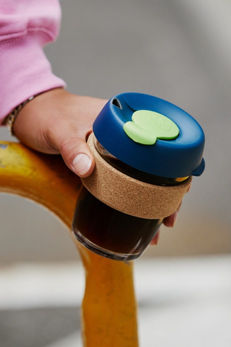 Woman holding KeepCup Brew Cork 12oz with coffee