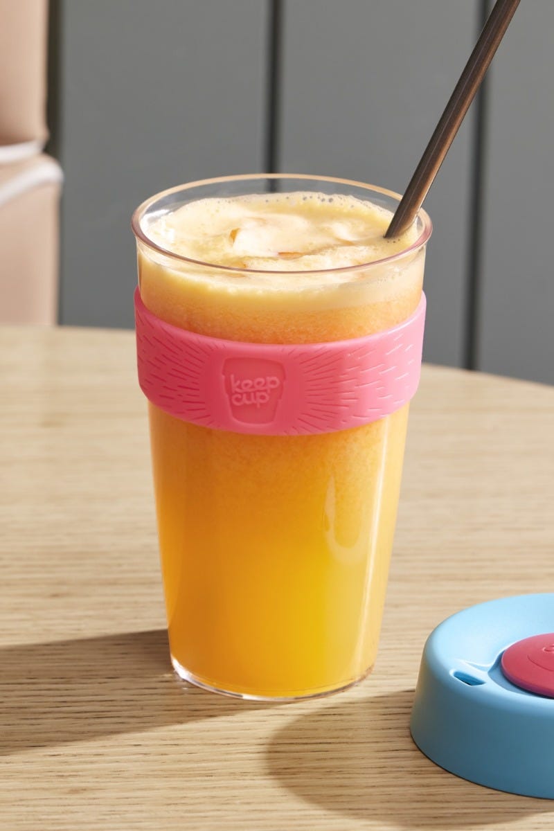 KeepCup Original Clear L 16oz sitting on table with juice