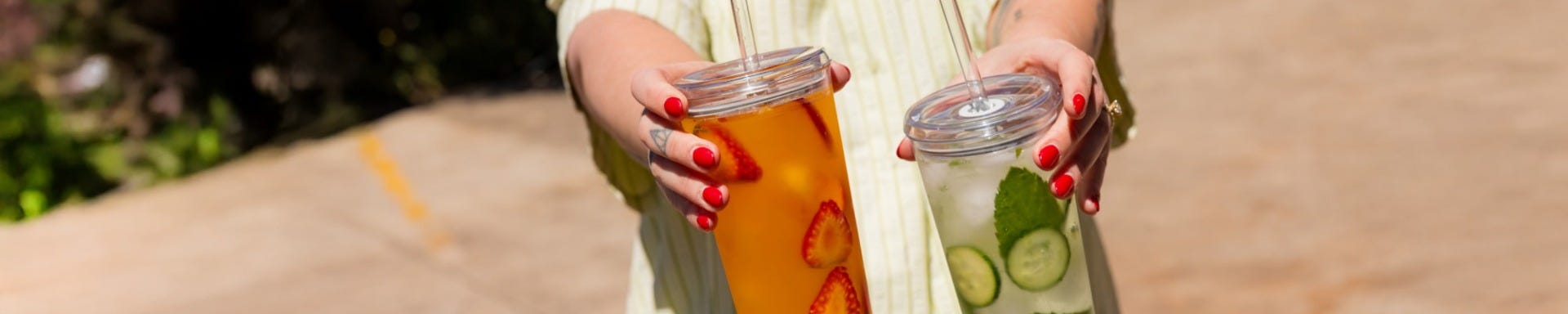 Woman holding up KeepCup Cold Cup Original with iced tea 