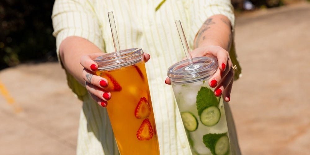 Woman holding up KeepCup Cold Cup Original with iced tea 